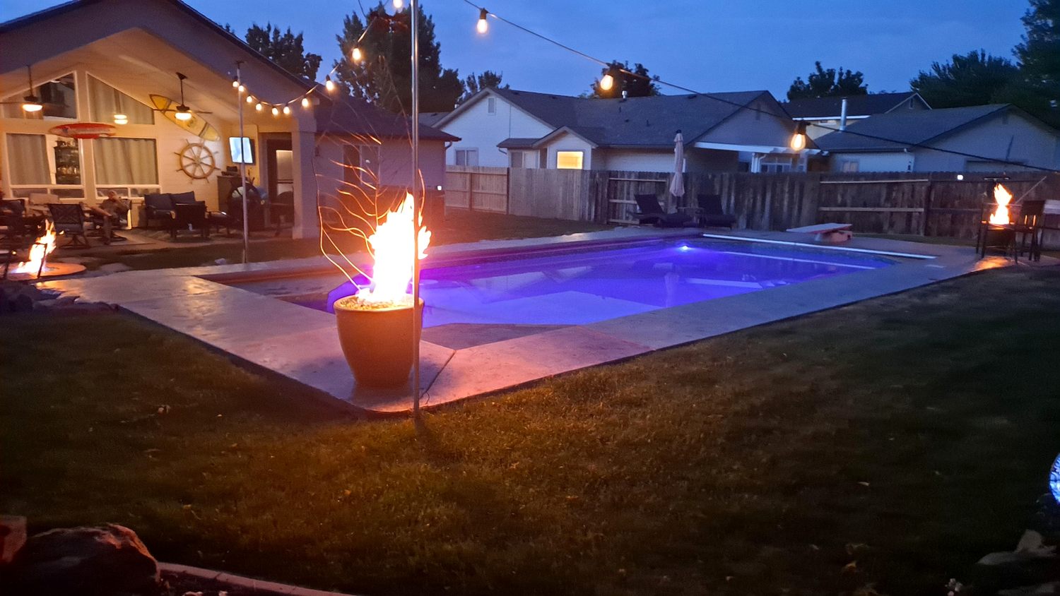 Illuminated backyard pool with fire features